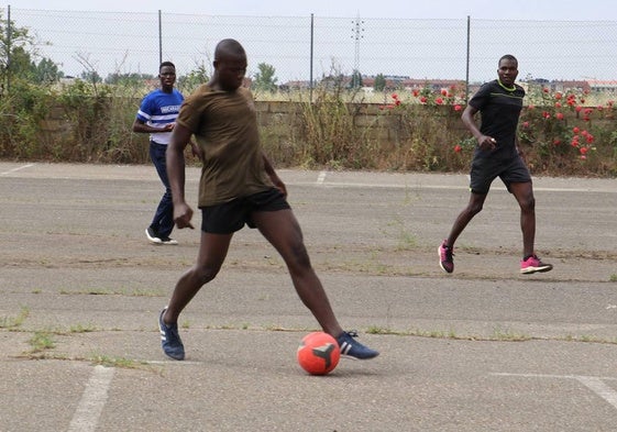 Un grupo de inmigrantes juega al balón en el chalé.