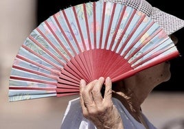 Una persona hace uso del abanico para pasar el calor en una iamgen de archivo.