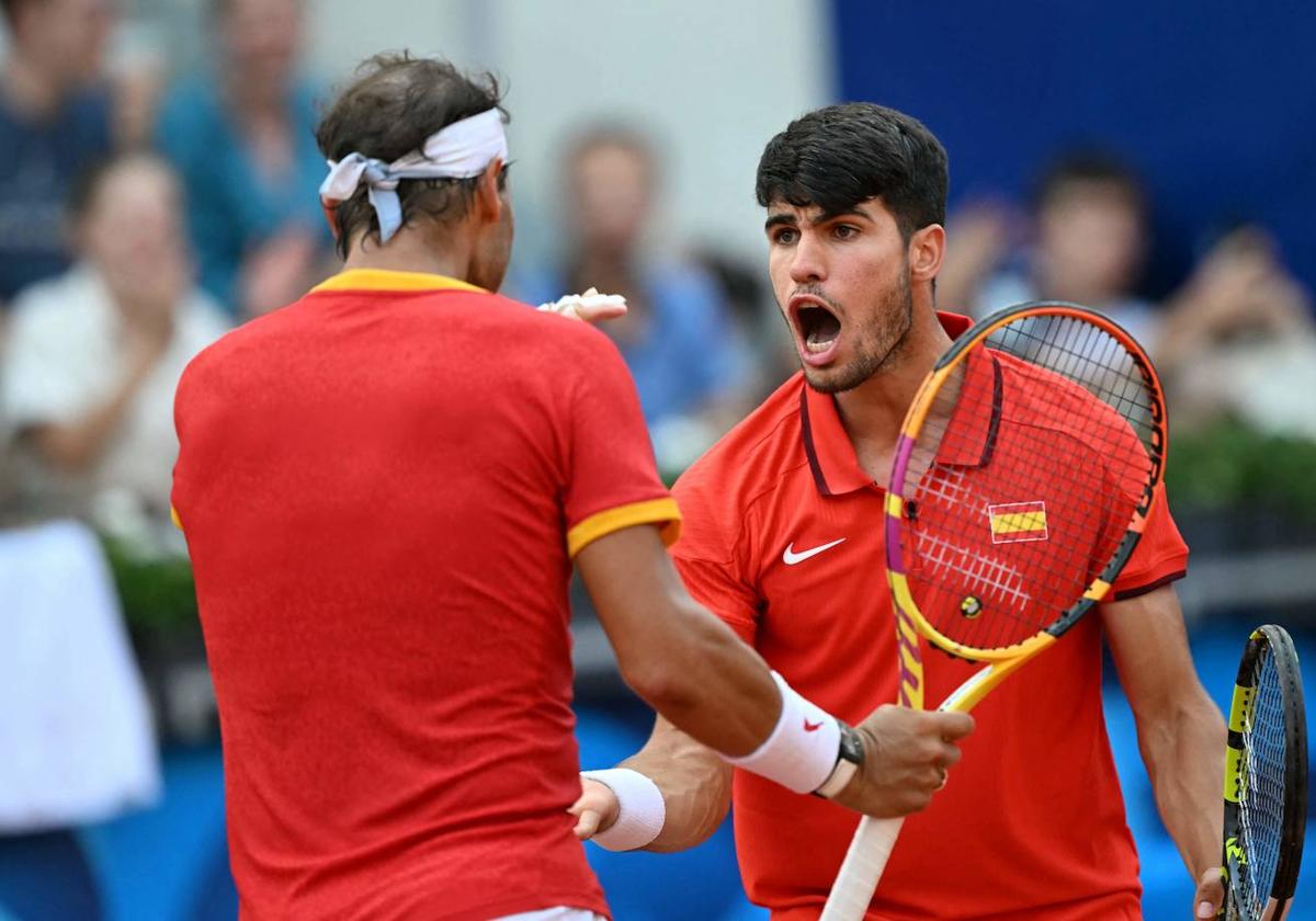 Carlos Alcaraz y Rafa Nadal celebran un punto.