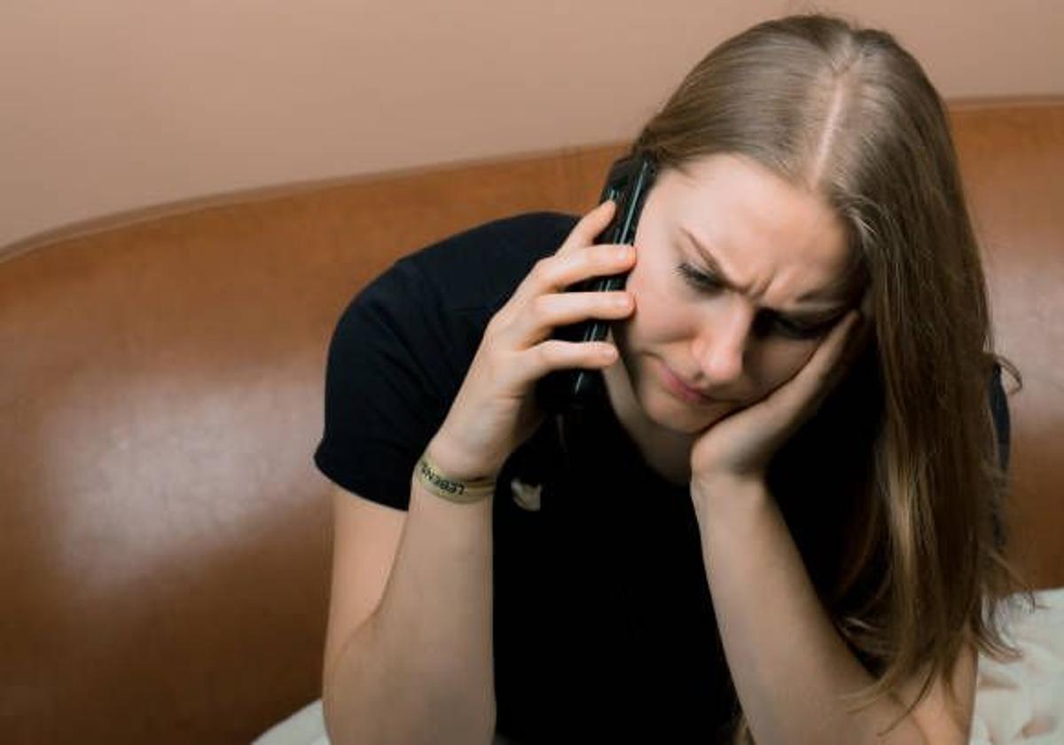 Mujer pidiendo ayuda telefónica.