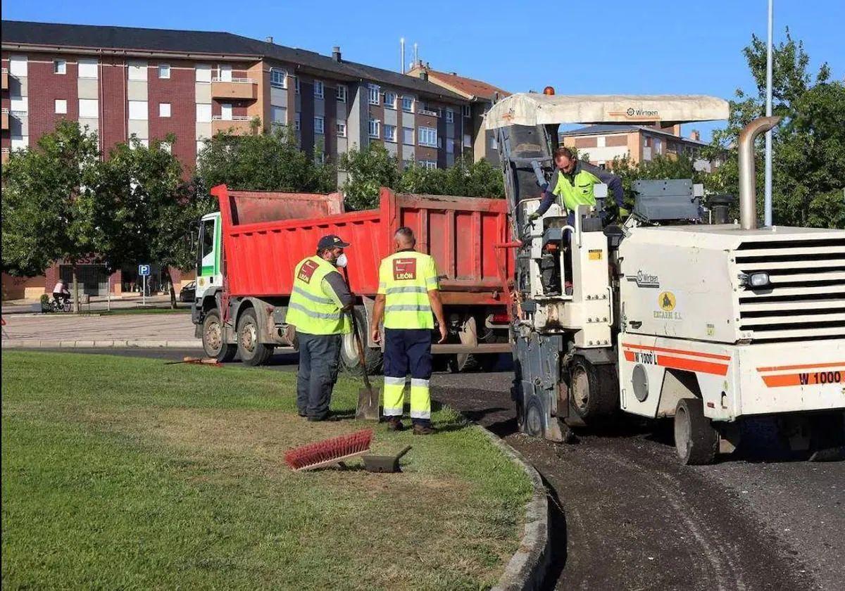 Operarios del Ayuntamiento asfaltan una carretera en León.