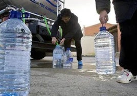 Vecinos se apoyan del agua potable de un camión cistierna.