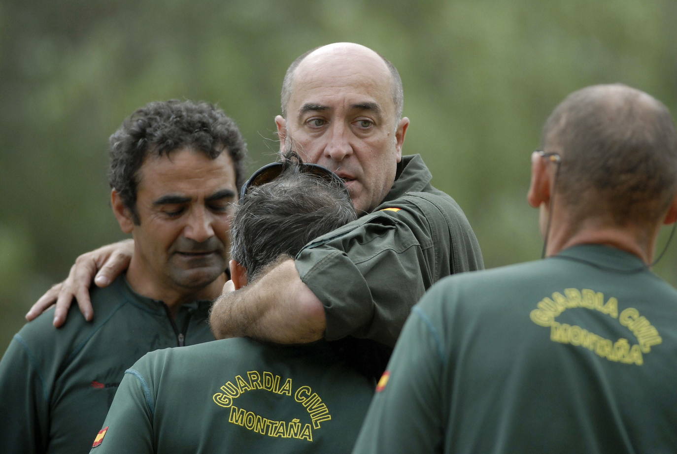 Compañeros de los tres guardias civiles fallecidos al caer su helicóptero cuando llevaban a cabo un rescate en la zona de Polinosa, término municipal de Maraña, en el norte de la provincia de León, se abrazan tras conocer el suceso.