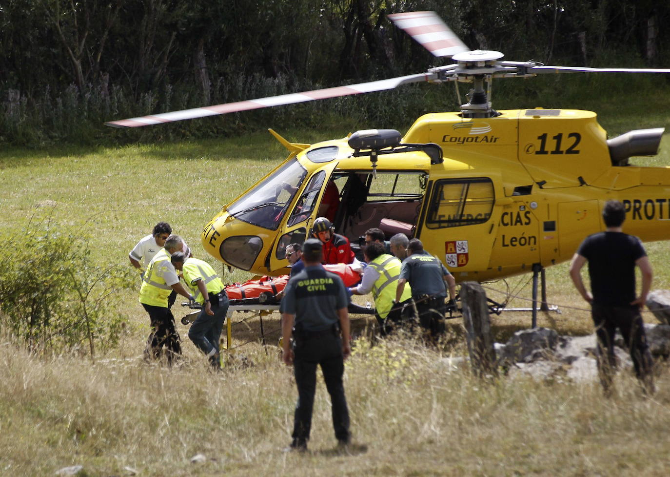 Un helicóptero del 112 de protección Ciudadana de Castilla y León en Maraña, con el cadáver de uno de los tres fallecidos al caer su helicóptero de la Guardia Civil cuando llevaban a cabo un rescate.