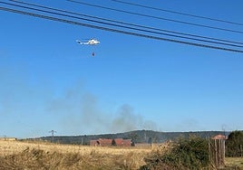 Imagen de un helicóptero apagando las llamas en Villasinta de Torío.