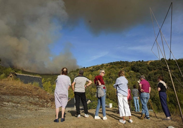 Varios vecinos observan con impotencia el humo procedente del incendio desde Tremor de Abajo.