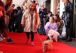 Una de las participantes más jóvenes desfila junto su mascota.