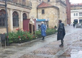 Turistas con chubasquero por el centro de León.