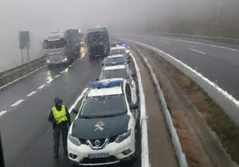 Camiones detenidos junto a la Guardia Civil ante el argayo.