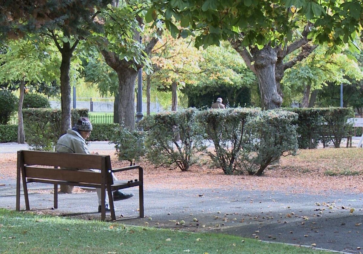 Imagen de archivo de un hombre descansando en un banco de un parque de León en otoño.