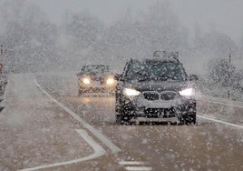 Vehículos circulando bajo una nevada en León.