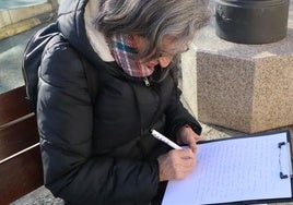 Voluntaria escribe una carta de respuesta a los afectados por la soledad no deseada.