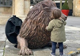 El león de la alcantarilla junto a un niño.