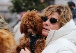 Una mujer junto a su perro en la cola para la bendición de San Antón