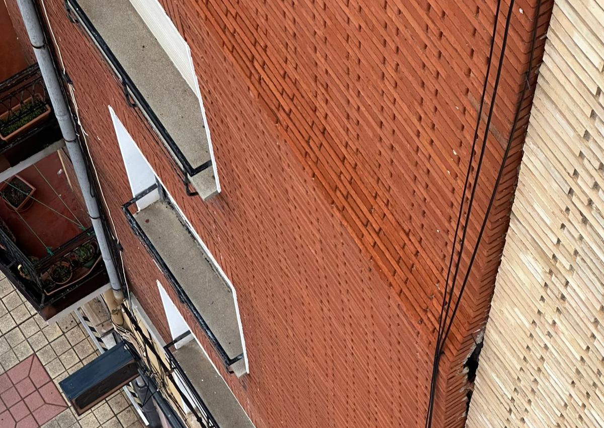 Imagen secundaria 1 - Fotogradías de la fachada del edificio y las ventanas con las persianas bajadas.