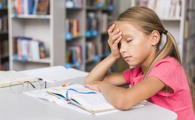 Imagen de una niña con dificultades ante un libro