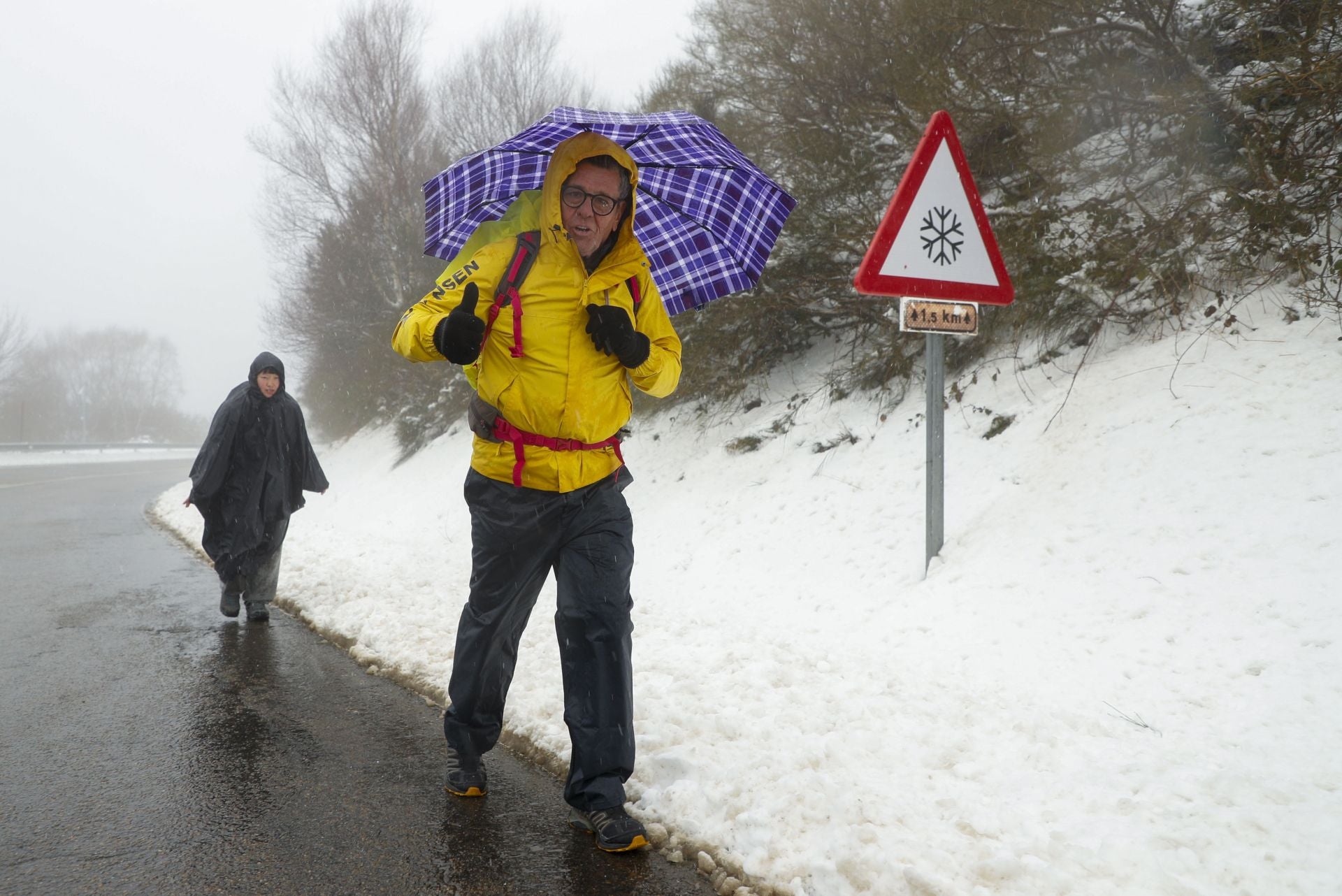 Dos peregrinos cruzan Piedrafita desde la provincia de León este martes.