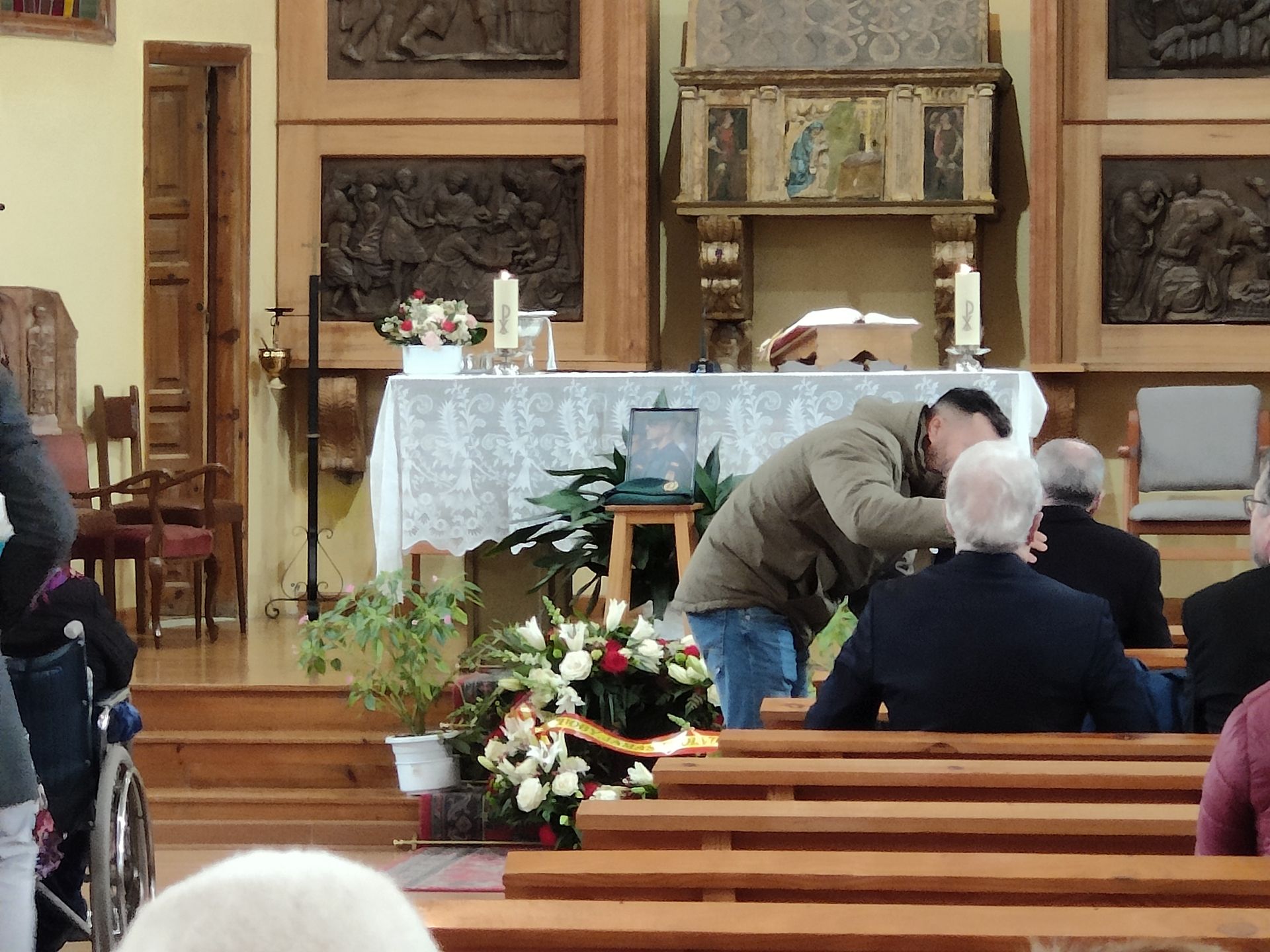 Un asistente a la misa habla con el padre de David momentos antes de comenzar la eucaristía en la Iglesia de Nogarejas.