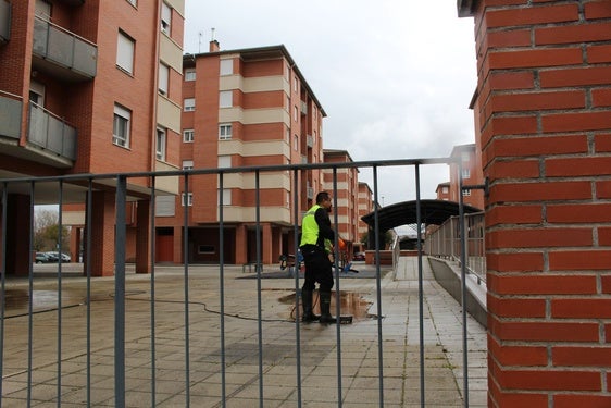 Un trabajador de una compañía de desatrancos trabaja en los desagües del bloque afectado por el rayo y el granizo en León.