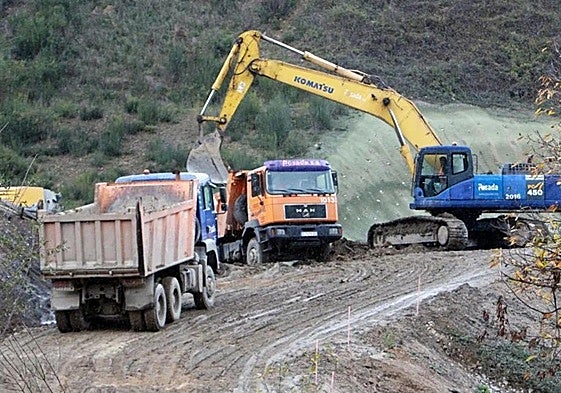 Camiones retirando toneladas de arcilla en la zona de la ladera que Adif está procediendo a vaciar