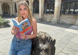Marina Lobo con su libro en el león de San Marcelo.