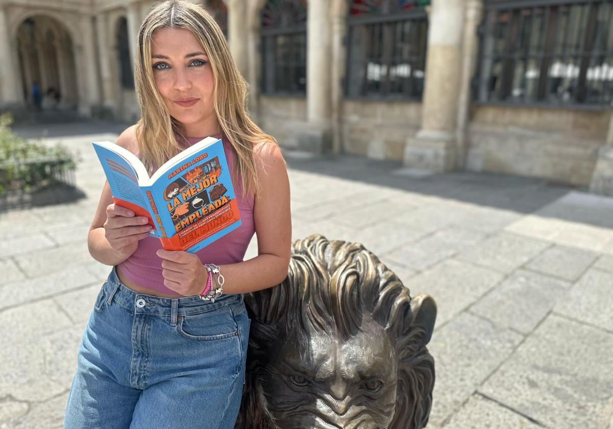 Marina Lobo con su libro en el león de San Marcelo.