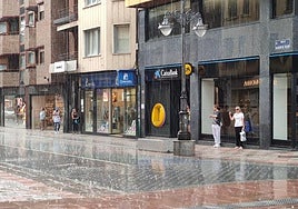 Varias personas se resguardan de la intensa lluvia durante una tormenta el sábado 30 de mayo en el centro de León.