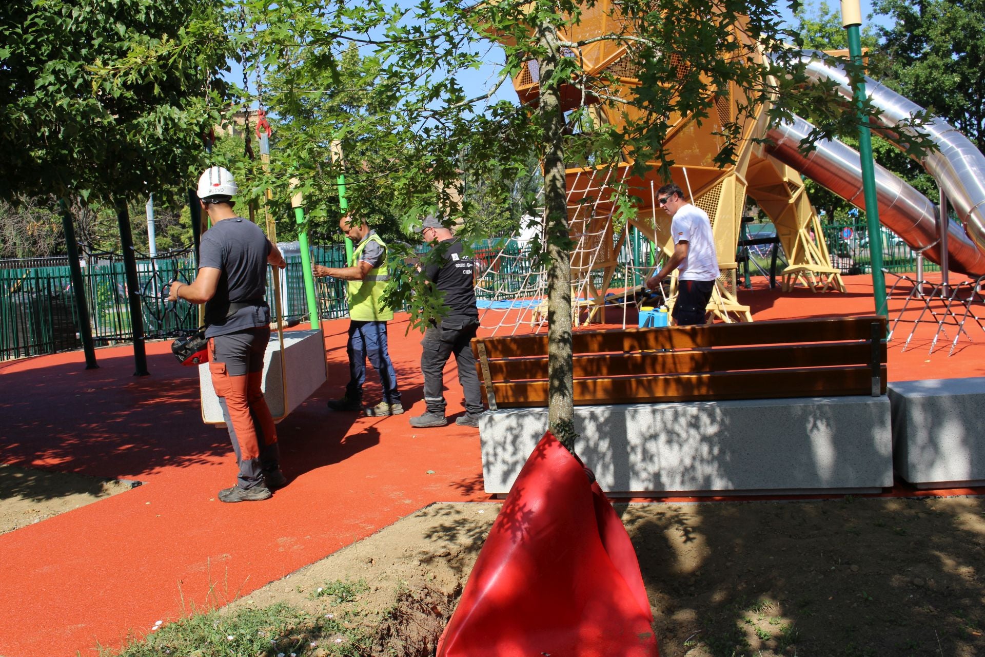Imagen principal - Colocación de los bancos del parque infantil con el león gigante en la explanada de los Pendones Leoneses.