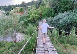 Un leonés cruza el puente colgante de La Flecha de Torío.