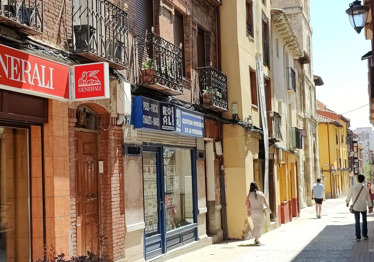 Imagen principal - Varios vecinos observan el edificio con el cartel de Proequip; la sede de la empresa en León; y otra imagen del edificio.