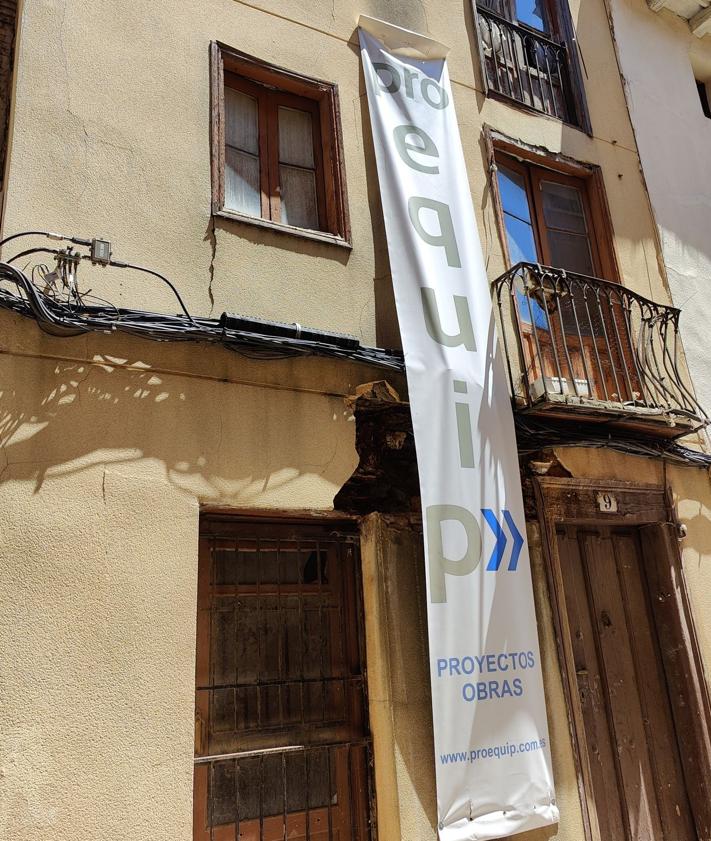 Imagen secundaria 2 - Varios vecinos observan el edificio con el cartel de Proequip; la sede de la empresa en León; y otra imagen del edificio.