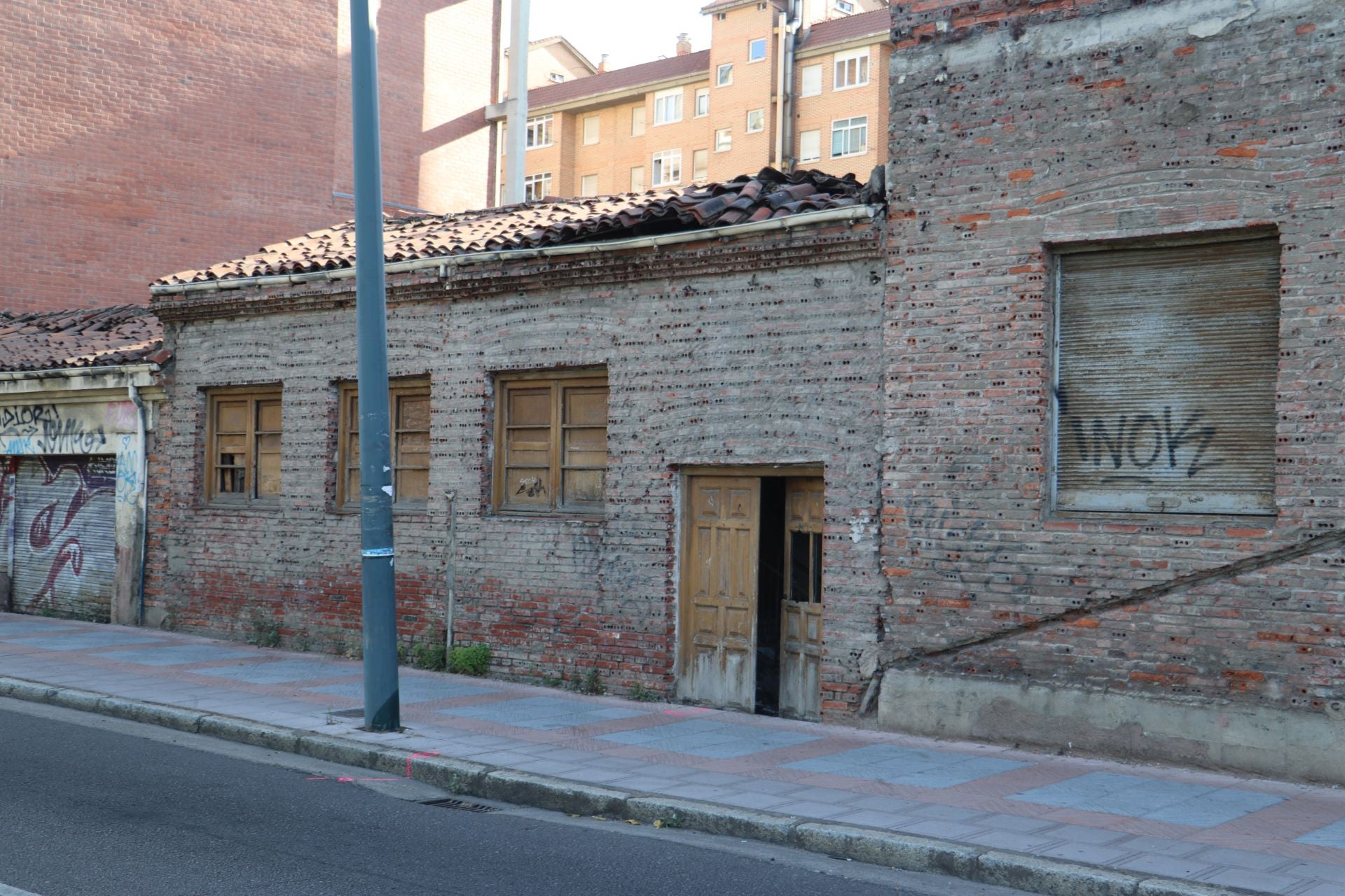 Imagen secundaria 1 - El edificio de Bodegas Armando, la zona en la que habitan los okupas actuales y la puerta por la que acceden.