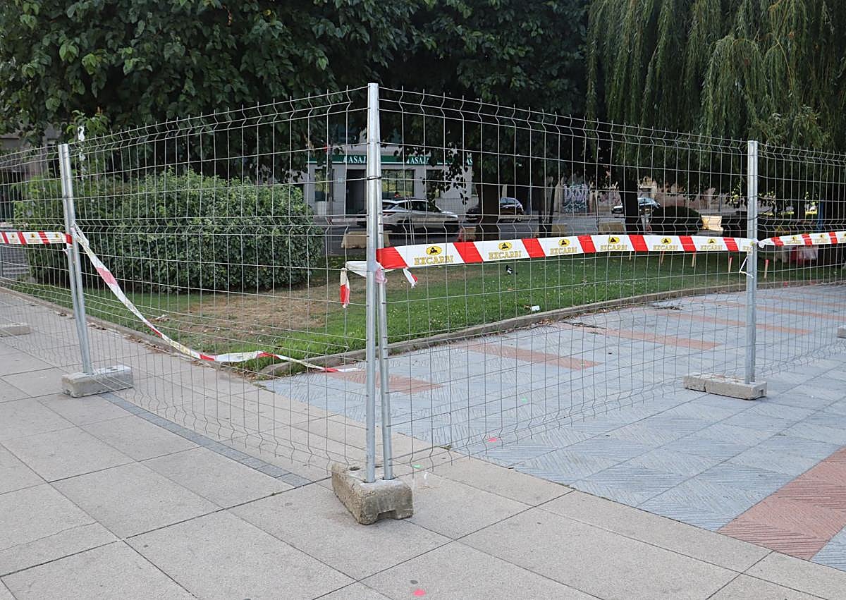 Imagen secundaria 1 - Estacas, vallado y pintura rosa y verde marcan la zona ajardinada y acera que desaparecerá para dejar espacio a la futura rotonda junto al Puente de los Leones.