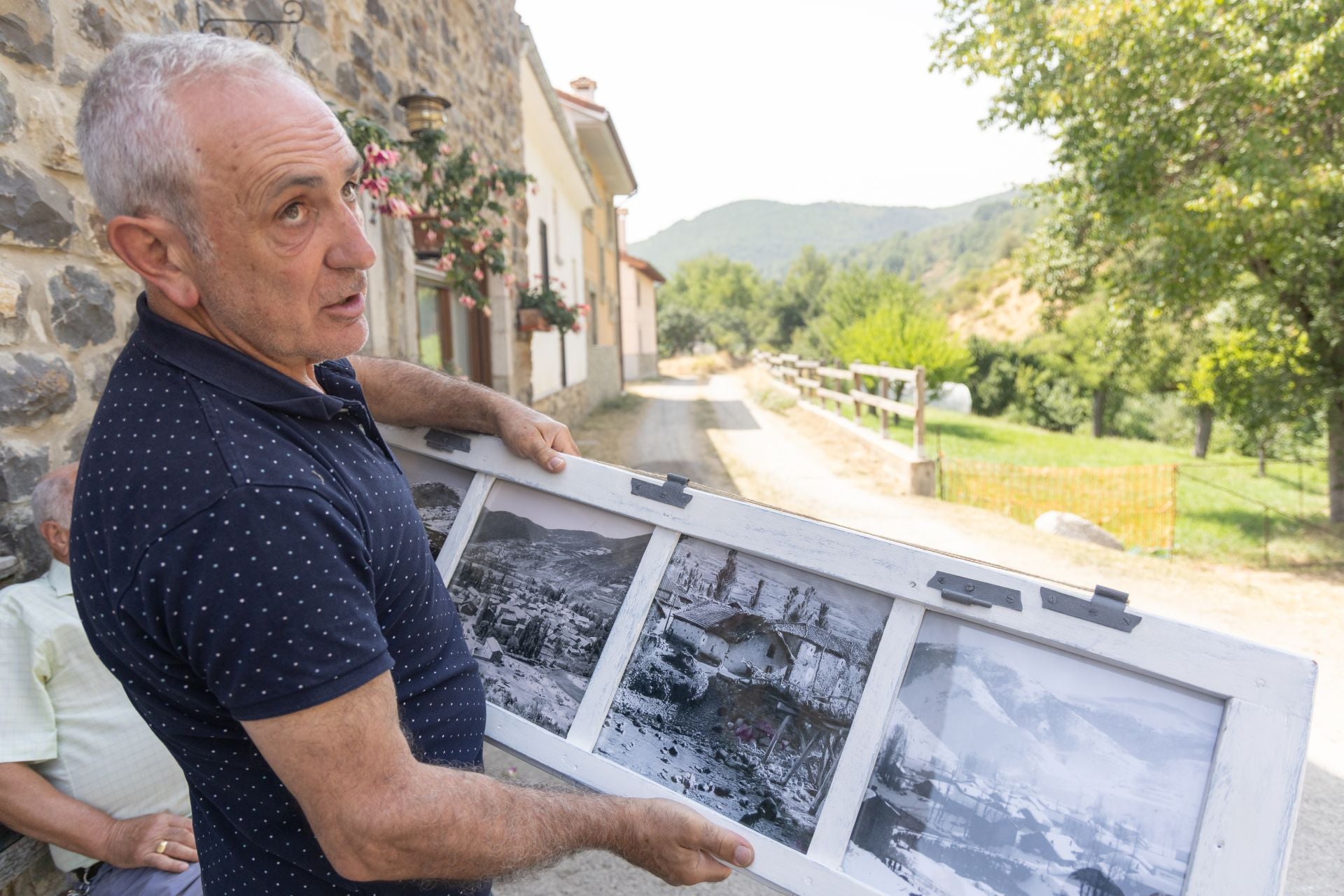 Un hombre muestra una fotografía comparatíva de cómo estaba el monte en los años 60 y como está ahora.