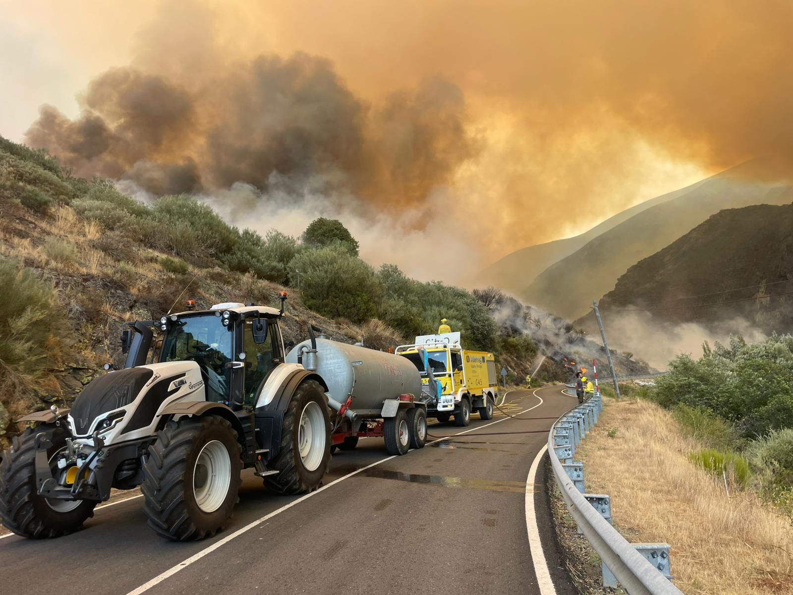 La cuba de un tractor llenando el depósito de una autobomba en el incendio de Boca de Huérgano.