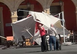 Varias sombrillas y sillas afectadas por el viento en la Plaza Mayor.