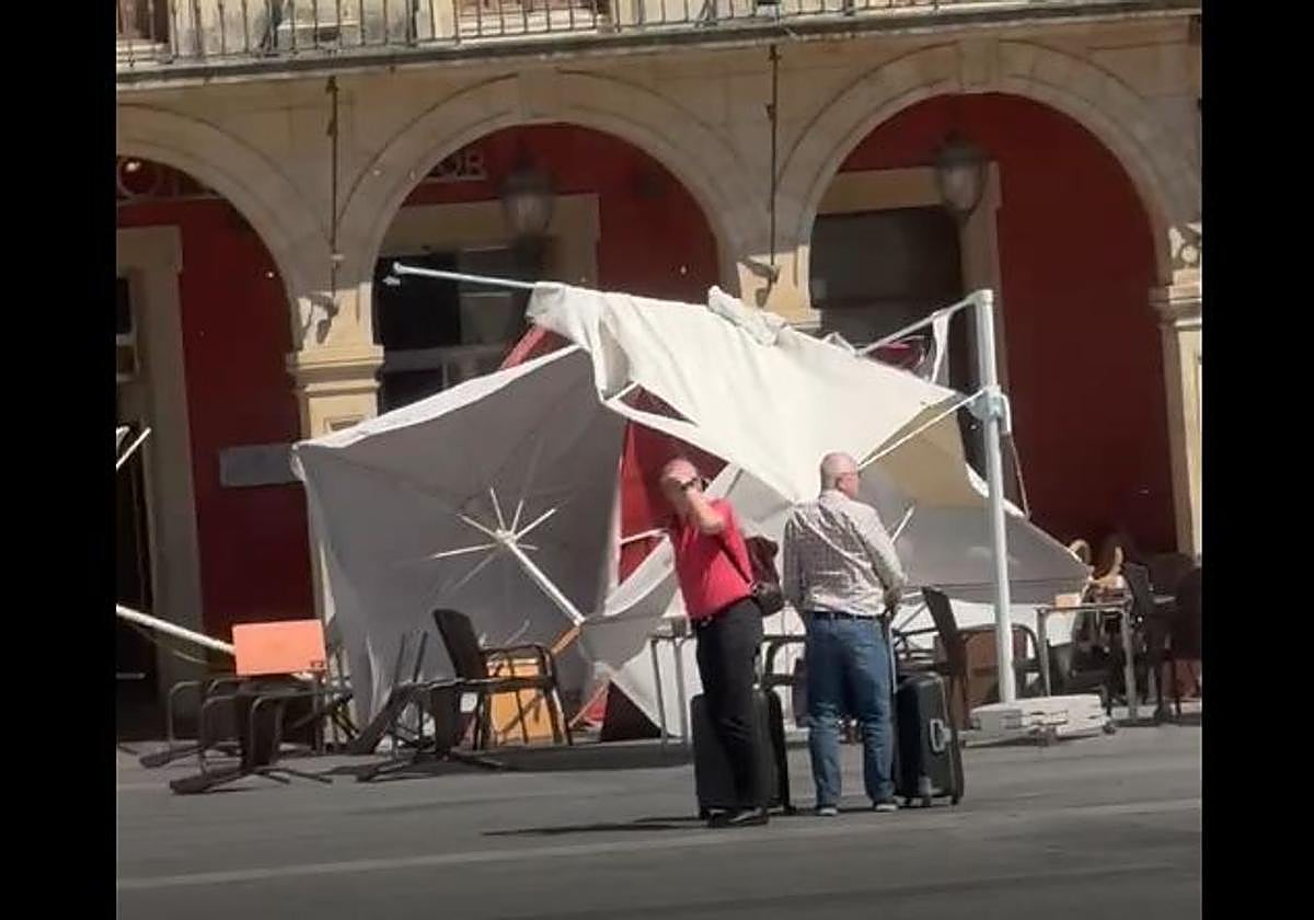 Varias sombrillas y sillas afectadas por el viento en la Plaza Mayor.