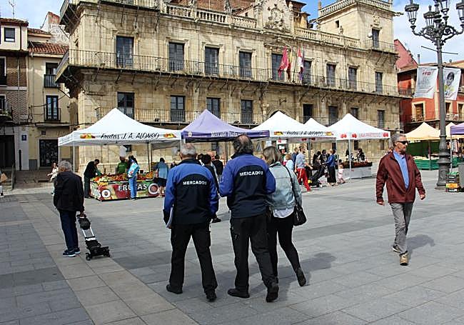 La concejala de Comercio, Consumo y Fiestas del ayuntamiento de León paseando por el mercado don dos funcionarios del consistorio.
