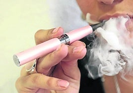 Una persona fumando un cigarrillo electrónico.