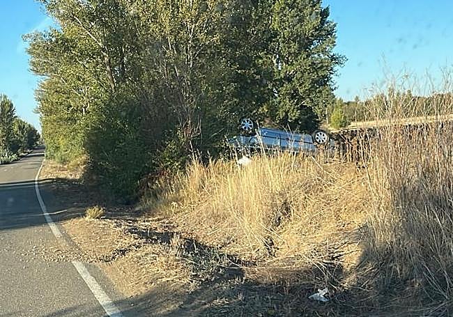 El coche volcado a la entrada del pueblo.