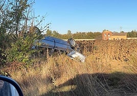 El coche volcado en la entrada del pueblo.