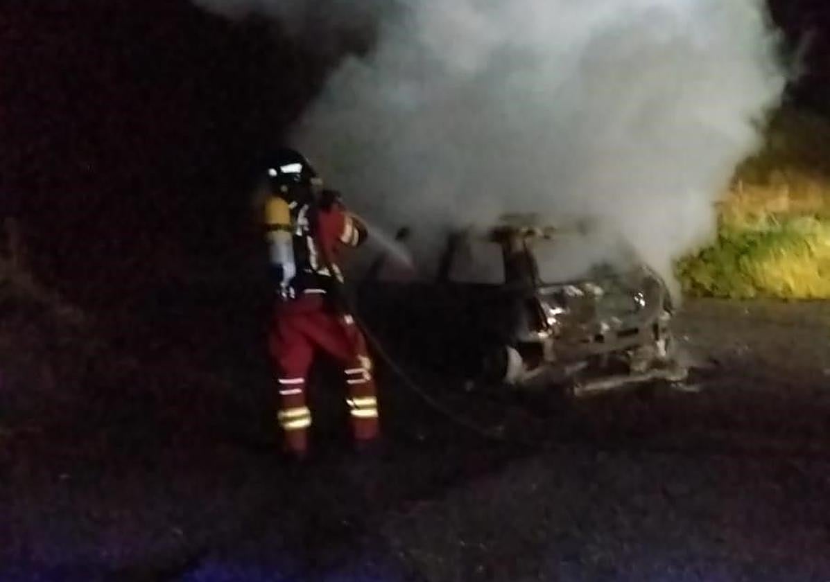 Bomberos del Sepeis sofocan las llamas en el coche.