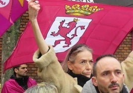 Una mujer sustenta una bandera de León.