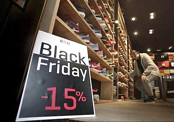 imagen de archivo de un dependiente trabajando en un comercio en plena campaña del Black Friday en León.
