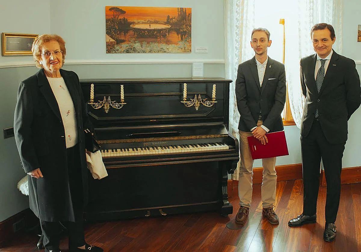 Imagen de archivo de Emilia Fernández Díez, donante, Carlos Varela, conservador jefe del Museo Casa Botines Gaudí y Raúl Fernández Sobrino, director del Museo, posan con el piano colocado en la recreación de la vivienda.