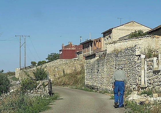 Un jubilado pasea por su pueblo en la provincia de León.
