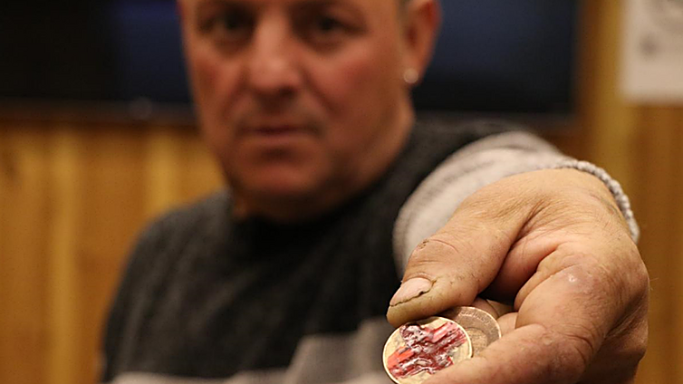 Jaime Oubiña Rodríguez muestra dos chapas del bar Miserias en León.