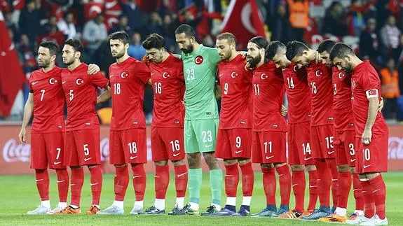 Los futbolistas turcos observan el minuto de silencio. 