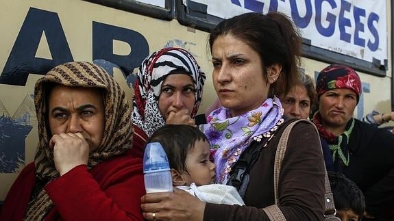 Inmigrantes y refugiados aguardan para conseguir ayuda en la frontera entre Grecia y Macedonia. 