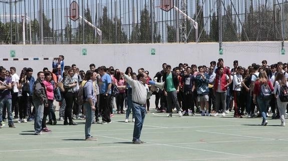 El jefe de estudios del instituto Ramón Arcas Meca da instrucciones con un megáfono a los alumnos durante la evacuación del centro. 